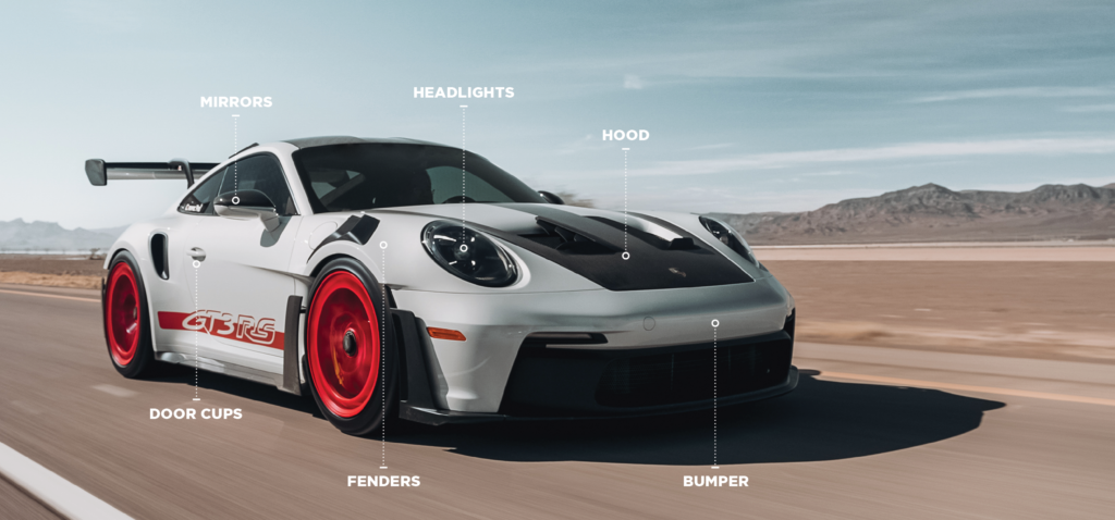 Diagram of a silver Porsche 911 GT3 RS labelling the areas paint protection film covers: hood, bumper, fenders, mirrors, headlights and door cups